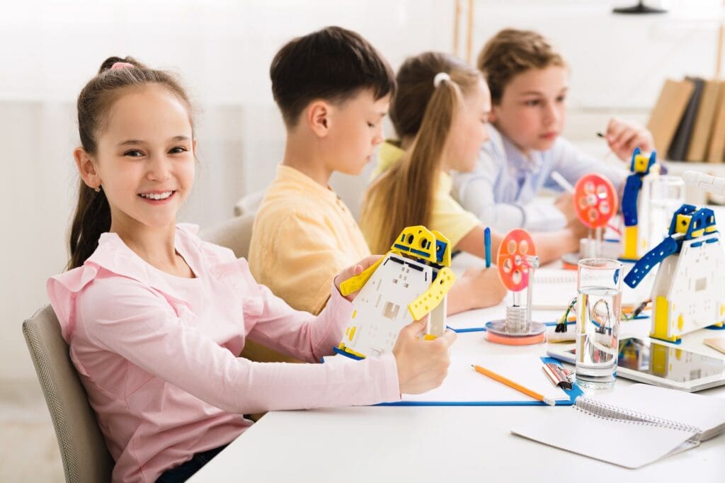 - svg+xml;charset=utf - Community Development Programs | Manifezt Foundation Stem education. Girl creating robot at lab