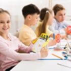 Stem education. Girl creating robot at lab STEM and Children Board Members